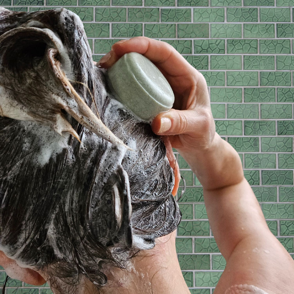 awaken shampoo bar being used in the shower