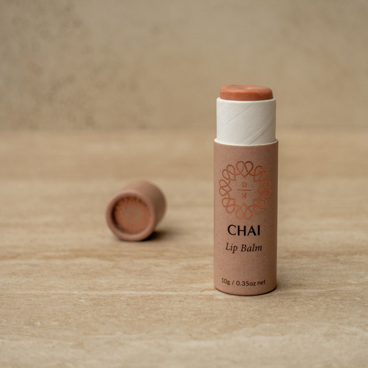 cardboard tube of chai lip balm slightly gold and shimmery 100% natural organic flavour oil like cinnamon and vanilla best lip balm in nz