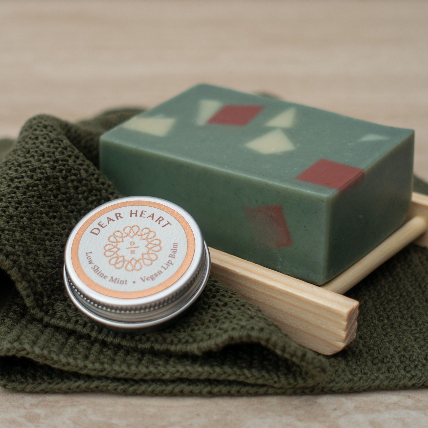 close up photo of handmade soap, wooden soap rack, lip balm and cotton wash cloth the perfect christmas gift box made in new zealand