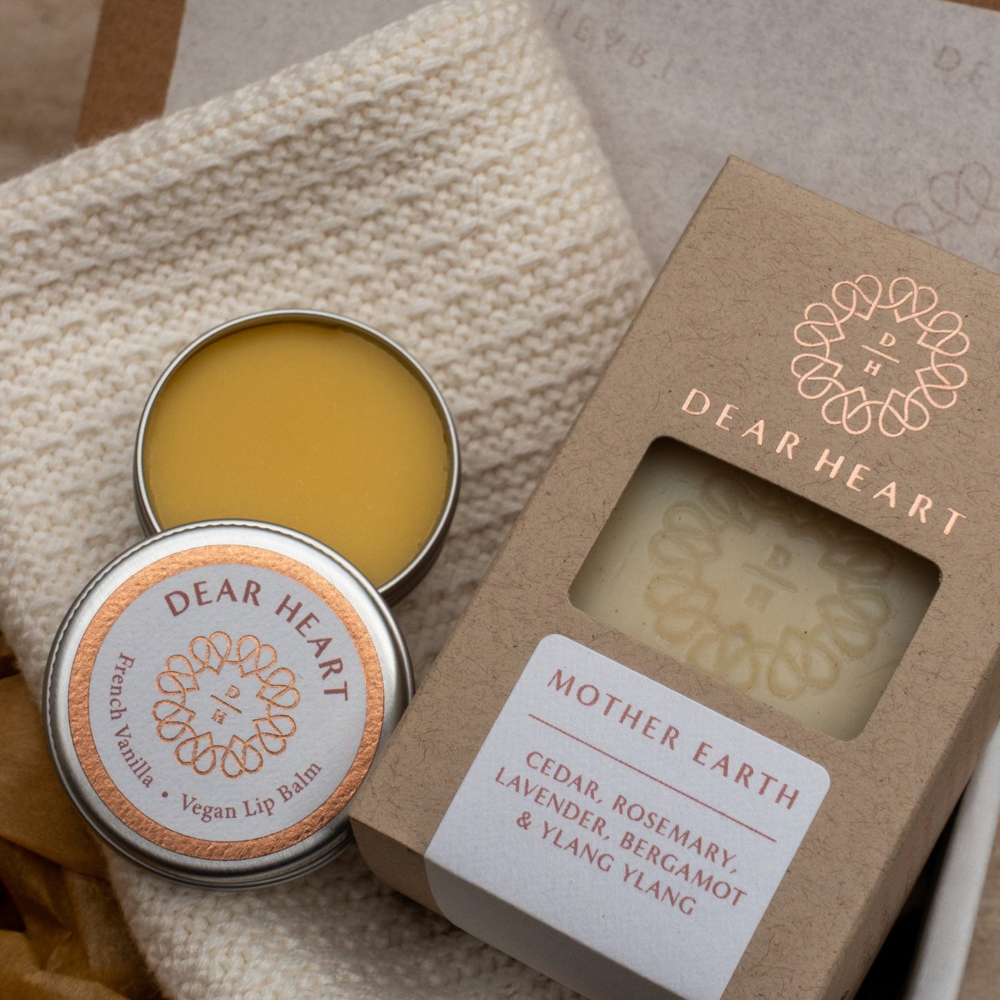 closeup of soap gift box containing handcrafted soap vanilla lip balm in an aluminum tin and thick face cloth in cream colour knitted style