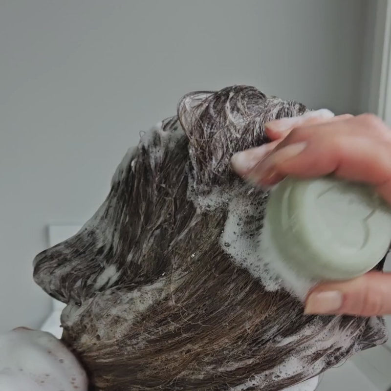 solid shampoo being used showing the lathering ability awaken shampoo bar made in nz