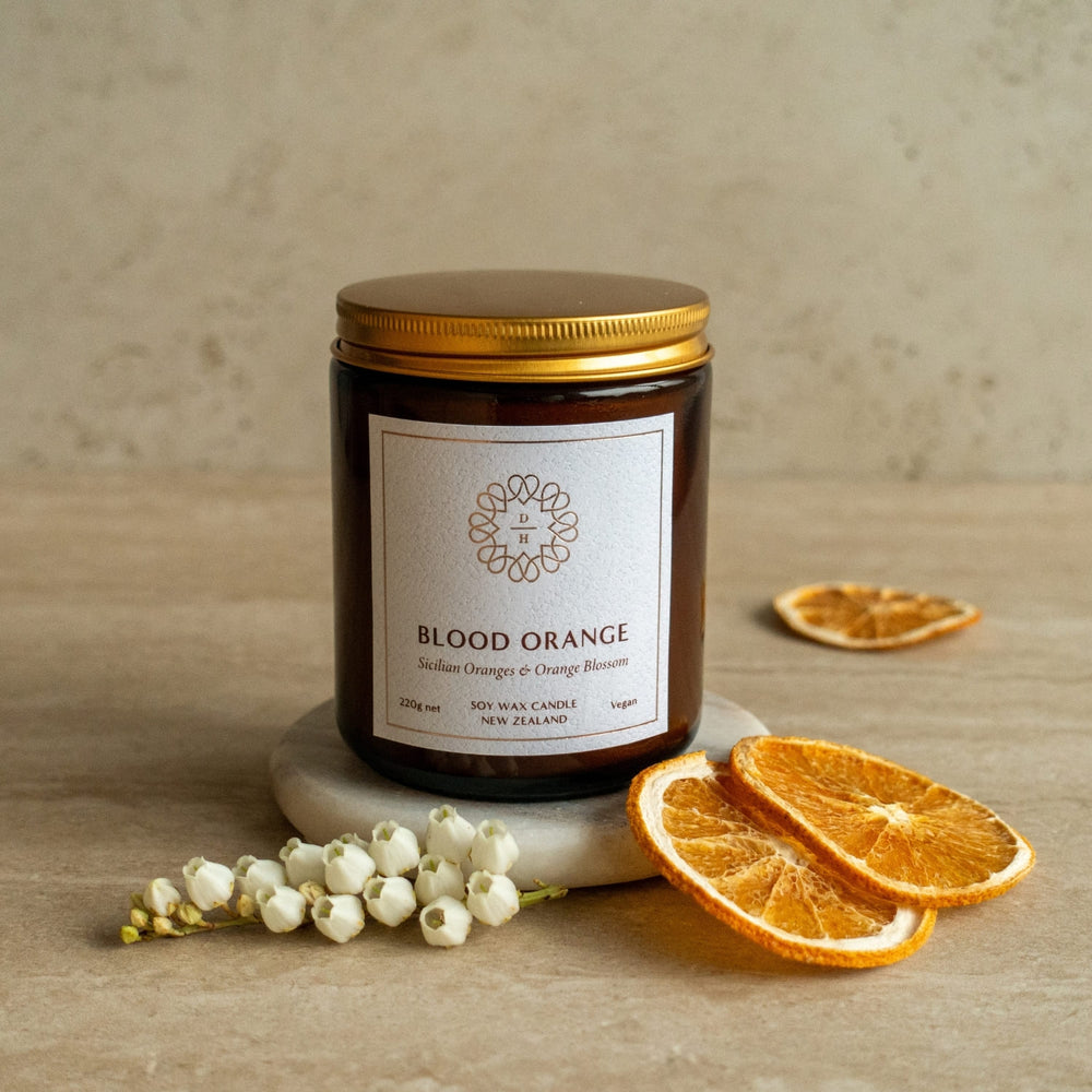 orange fragranced soy candle in amber glass jar with gold lid made in nz