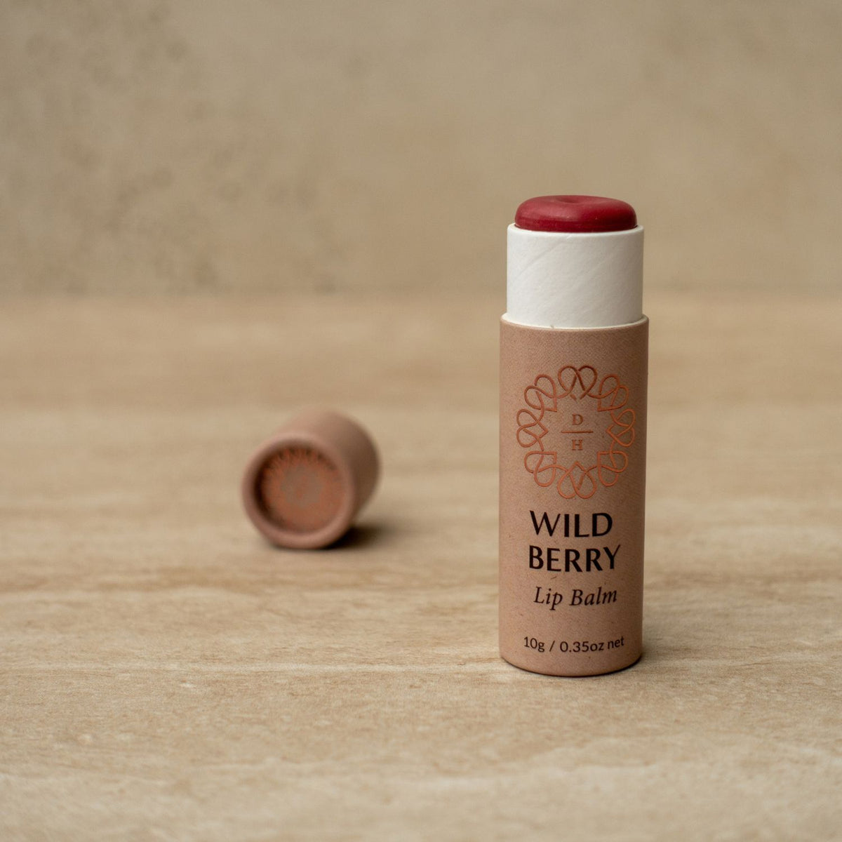 vegan lip balm in a cardboard compostable tube wild berry flavour lightly tinted pink red colour made in nz